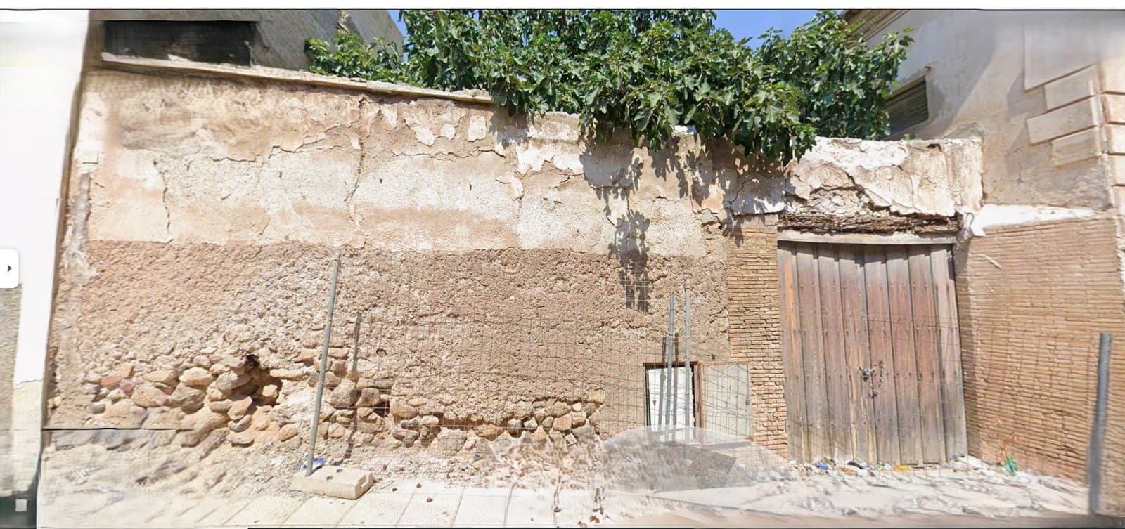 Solar y muro antes de la rehabilitación